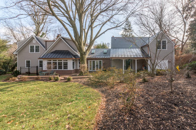 Example of a large classic beige two-story concrete fiberboard exterior home design in DC Metro with a shingle roof
