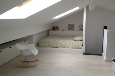Mid-sized contemporary gender-neutral kids' room in Madrid with white walls, laminate floors and white floor.
