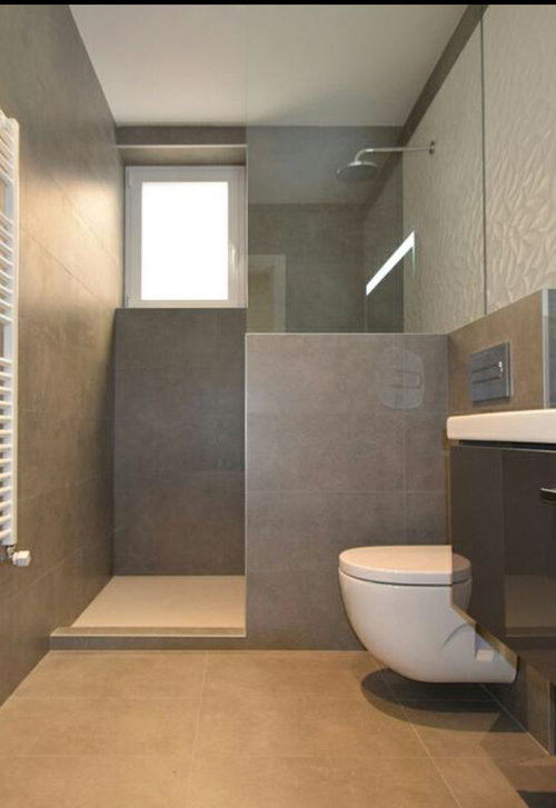 Plato de ducha y mampara en un baño de mármol