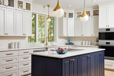 Example of a mid-sized trendy u-shaped medium tone wood floor and brown floor eat-in kitchen design in Minneapolis with an undermount sink, flat-panel cabinets, beige cabinets, quartz countertops, beige backsplash, quartz backsplash, stainless steel appliances, an island and beige countertops