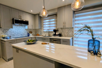 Inspiration for a mid-sized transitional l-shaped porcelain tile and gray floor enclosed kitchen remodel in Montreal with a double-bowl sink, shaker cabinets, gray cabinets, quartzite countertops, gray backsplash, marble backsplash, stainless steel appliances, an island and beige countertops