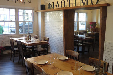 Immagine di una sala da pranzo aperta verso la cucina rustica di medie dimensioni con pareti bianche, pavimento in laminato e pavimento marrone