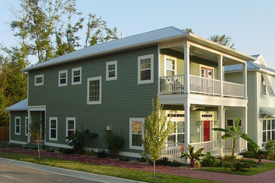 Mid-sized elegant green two-story concrete fiberboard exterior home photo in Miami with a hip roof
