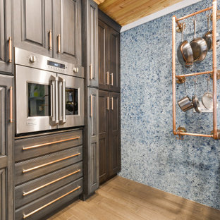 Идея дизайна: маленькая угловая кухня в стиле фьюжн с кладовкой, раковиной в стиле кантри, фасадами с выступающей филенкой, синими фасадами, столешницей из акрилового камня, синим фартуком, фартуком из стекла, техникой из нержавеющей стали, полом из бамбука, островом, коричневым полом и белой столешницей