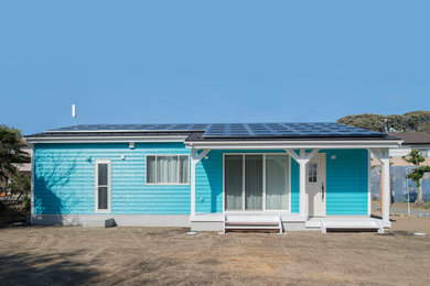 This is an example of a small beach style one-storey blue house exterior in Other with a shed roof and a mixed roof.