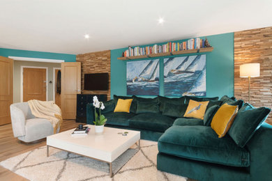Modelo de sala de estar abierta contemporánea de tamaño medio con suelo laminado, televisor colgado en la pared, suelo marrón y panelado