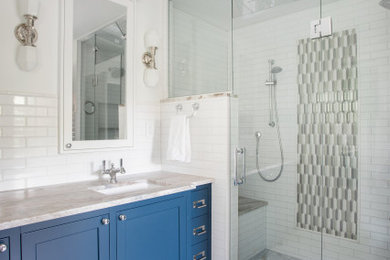 Example of a mid-sized classic master white tile and subway tile marble floor, white floor and double-sink bathroom design in Minneapolis with recessed-panel cabinets, a two-piece toilet, white walls, a drop-in sink, marble countertops, a hinged shower door, beige countertops and a built-in vanity
