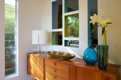 Photo of a midcentury entryway in Los Angeles with beige walls and light hardwood floors.
