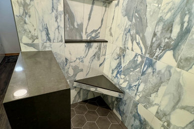 Bathroom - mid-sized transitional multicolored tile and porcelain tile vinyl floor, brown floor and double-sink bathroom idea in Omaha with shaker cabinets, gray cabinets, a one-piece toilet, blue walls, an undermount sink, quartz countertops, a hinged shower door, white countertops and a freestanding vanity