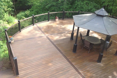 Inspiration for a huge modern backyard deck remodel in Other with a pergola