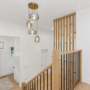 Modern Foyer with Vertical Slat Divider and Layered Pendant Lighting