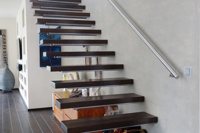 Inspiration for a contemporary wood floating staircase in Cologne with metal railing.