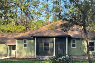 Inspiration for an eclectic green concrete fiberboard and board and batten house exterior remodel in Jacksonville with a shingle roof and a brown roof