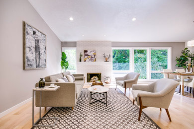 Inspiration for a mid-sized transitional formal and open concept light wood floor and brown floor living room remodel in Portland with gray walls, a standard fireplace, a brick fireplace and no tv