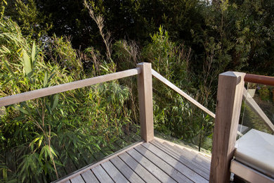 Modelo de escalera en L actual sin contrahuella con escalones de madera y barandilla de vidrio