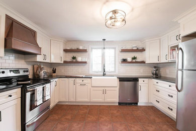 Example of a mid-sized country u-shaped porcelain tile and brown floor enclosed kitchen design in Boston with a farmhouse sink, recessed-panel cabinets, white cabinets, granite countertops, white backsplash, subway tile backsplash, stainless steel appliances, no island and gray countertops