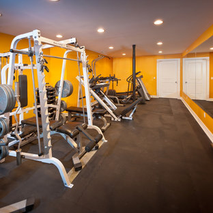 ニューヨークの大きいコンテンポラリースタイルのおしゃれなトレーニングルーム (黄色い壁、黒い床) の写真