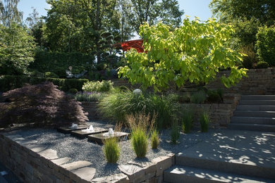 Landhaus Gartenmauer im Sommer mit direkter Sonneneinstrahlung und Natursteinplatten in Sonstige