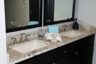 Inspiration for a mid-sized timeless master ceramic tile and beige floor bathroom remodel with flat-panel cabinets, black cabinets, white walls, an undermount sink and granite countertops