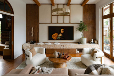 Living room - mid-sized contemporary enclosed medium tone wood floor and brown floor living room idea in Houston with beige walls and a wall-mounted tv