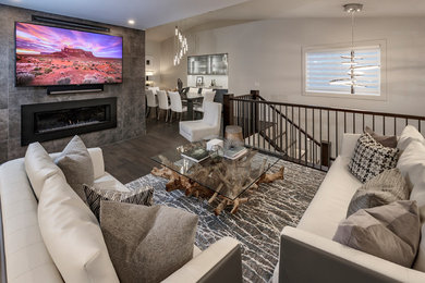 Family room - mid-sized modern open concept dark wood floor and brown floor family room idea in Calgary with gray walls, a two-sided fireplace, a tile fireplace and a wall-mounted tv