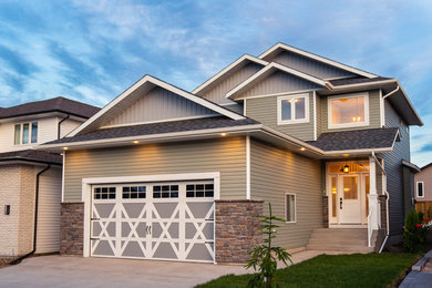 Mid-sized elegant green two-story stone exterior home photo in Other with a shingle roof