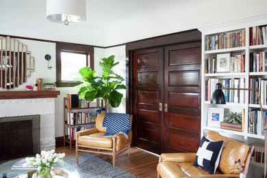 Living room - mid-sized eclectic enclosed medium tone wood floor and brown floor living room idea in Portland with white walls, a standard fireplace, a brick fireplace and no tv