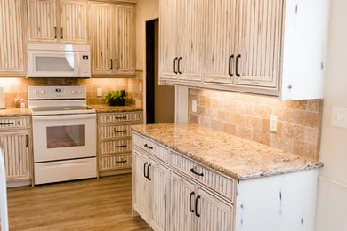 Large transitional u-shaped light wood floor and brown floor eat-in kitchen photo in Oklahoma City with louvered cabinets, distressed cabinets, marble countertops, multicolored backsplash, stone tile backsplash, white appliances, a peninsula and an undermount sink