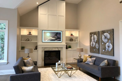 Inspiration for a mid-sized traditional family room in Toronto with a standard fireplace, a stone fireplace surround and a wall-mounted tv.