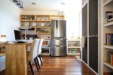 Example of a small eclectic single-wall medium tone wood floor open concept kitchen design in Other with a single-bowl sink, open cabinets, light wood cabinets, wood countertops, brown backsplash, ceramic backsplash, stainless steel appliances and a peninsula
