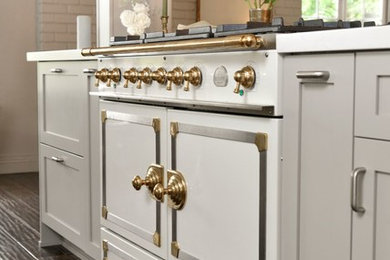 Inspiration for a mid-sized modern u-shaped medium tone wood floor eat-in kitchen remodel in San Diego with a single-bowl sink, shaker cabinets, gray cabinets, quartz countertops, stainless steel appliances, an island and brick backsplash