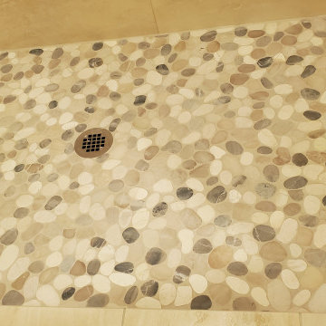 Striking 12 x 24 tiles installed on shower walls with a decorative pebble floor