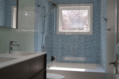 Example of a large trendy master blue tile and mosaic tile porcelain tile and gray floor bathroom design in San Francisco with an integrated sink, flat-panel cabinets, dark wood cabinets, a two-piece toilet, brown walls, quartz countertops and a hinged shower door