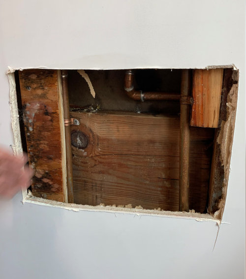 Water leaking from shower pipes wetting wood stud inside wall