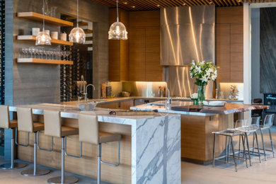 Inspiration for a mid-sized contemporary u-shaped porcelain tile and beige floor eat-in kitchen remodel in Los Angeles with an undermount sink, flat-panel cabinets, dark wood cabinets, marble countertops, metallic backsplash, metal backsplash, stainless steel appliances and an island