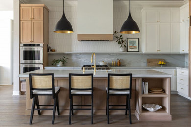 Inspiration for a large modern l-shaped brown floor open concept kitchen remodel in Sacramento with a farmhouse sink, shaker cabinets, white cabinets, quartzite countertops, white backsplash, ceramic backsplash, stainless steel appliances, an island and gray countertops