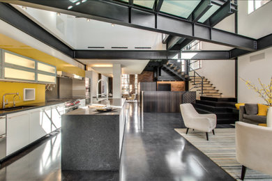 Inspiration for a large modern galley concrete floor open concept kitchen remodel in Chicago with a farmhouse sink, flat-panel cabinets, white cabinets, concrete countertops, yellow backsplash, porcelain backsplash, stainless steel appliances and an island