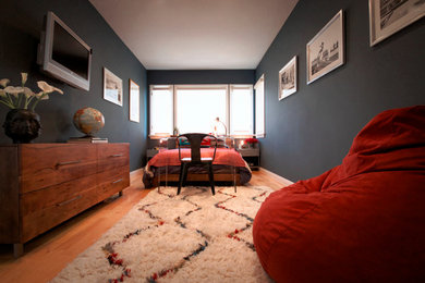 This is an example of a small eclectic guest bedroom in Los Angeles with blue walls, light hardwood floors and no fireplace.