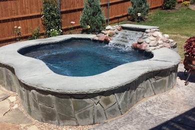 This is an example of a small asian backyard custom-shaped natural pool in Dallas with a hot tub and stamped concrete.