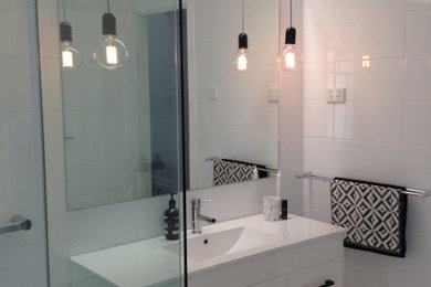 This is an example of a mid-sized scandinavian master bathroom in Perth with white cabinets, a freestanding tub, white walls, an integrated sink, white floor, a hinged shower door, white benchtops, a floating vanity, porcelain tile and porcelain floors.