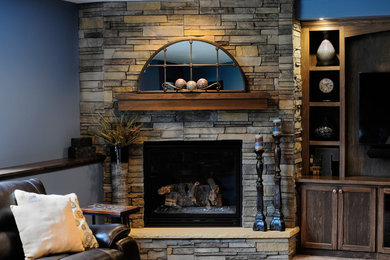 Inspiration for a mid-sized timeless look-out vinyl floor basement remodel in Minneapolis with blue walls and a stone fireplace