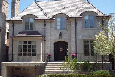 Inspiration for a mid-sized beige two-story stone gable roof remodel in Toronto