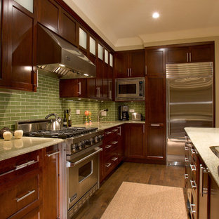 Ispirazione per una cucina design con elettrodomestici in acciaio inossidabile, ante con riquadro incassato, ante in legno bruno, top in granito e paraspruzzi verde