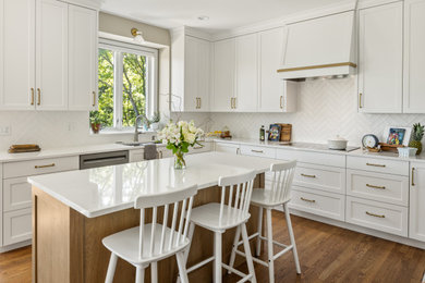 Open concept kitchen - large traditional u-shaped medium tone wood floor and brown floor open concept kitchen idea in Minneapolis with an undermount sink, recessed-panel cabinets, white cabinets, quartzite countertops, white backsplash, ceramic backsplash, stainless steel appliances, an island and white countertops