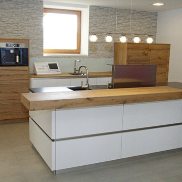 Moderne  Küche mit Echoholzfronten und Lackfronten in Weiß kombiniert.