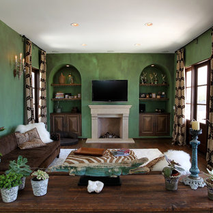 Large mediterranean formal enclosed living room in Los Angeles with green walls, dark hardwood flooring, a wall mounted tv, a standard fireplace, a stone fireplace surround and brown floors.