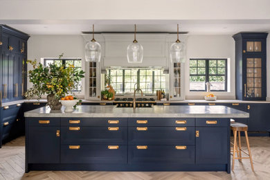 Design ideas for a large classic kitchen/diner in Cheshire with a belfast sink, shaker cabinets, blue cabinets, quartz worktops, black appliances, an island and grey worktops.