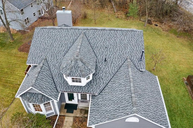 Diseño de fachada gris tradicional con tejado de teja de madera