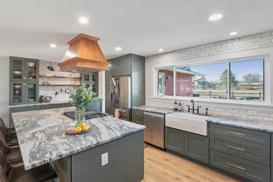 Example of a large country l-shaped vinyl floor, beige floor and tray ceiling eat-in kitchen design in Denver with a farmhouse sink, shaker cabinets, green cabinets, granite countertops, white backsplash, brick backsplash, stainless steel appliances, an island and gray countertops