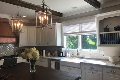 Inspiration for a large transitional u-shaped kitchen in Baltimore with a farmhouse sink, white splashback, subway tile splashback, stainless steel appliances, with island and white benchtop.